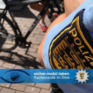 Polizeiabzeichen an einer Polizeiuniform, Fahrräder im Hintergrund