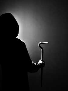 dunkel gekleidete Person, die eine Brechstange in der Hand hält